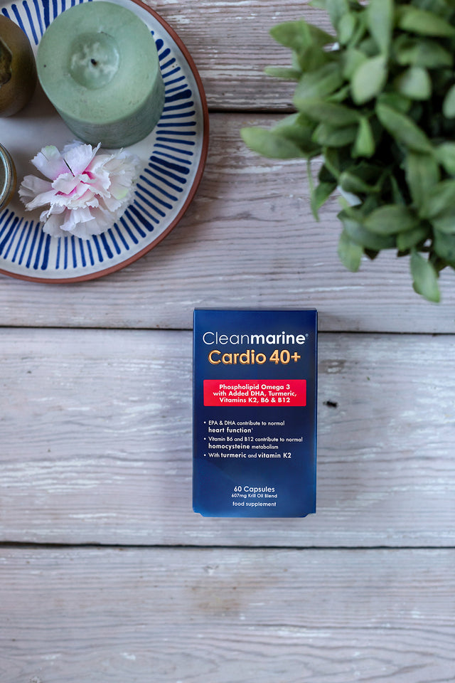 Box of Cleanmarine Cardio 40+ on a wooden surface with a candle and plant in the background