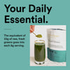 Green smoothie being poured into a glass with a package of Udi's Choice Beyond Greens on a teal background.