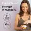 Woman holding a bottle of Udo's Choice supplement with product details on a light purple background.